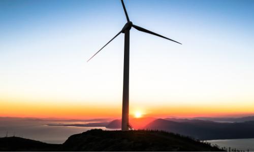 A wind turbine at sunset near the sea