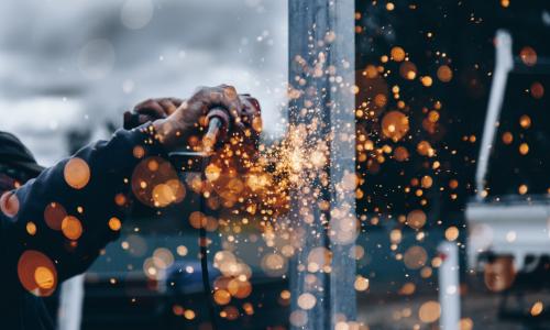 Photo of person working with a power tool and sending up sparks