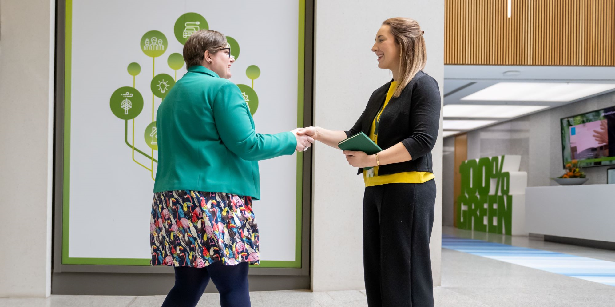 Stakeholder and employee shaking hands in office building